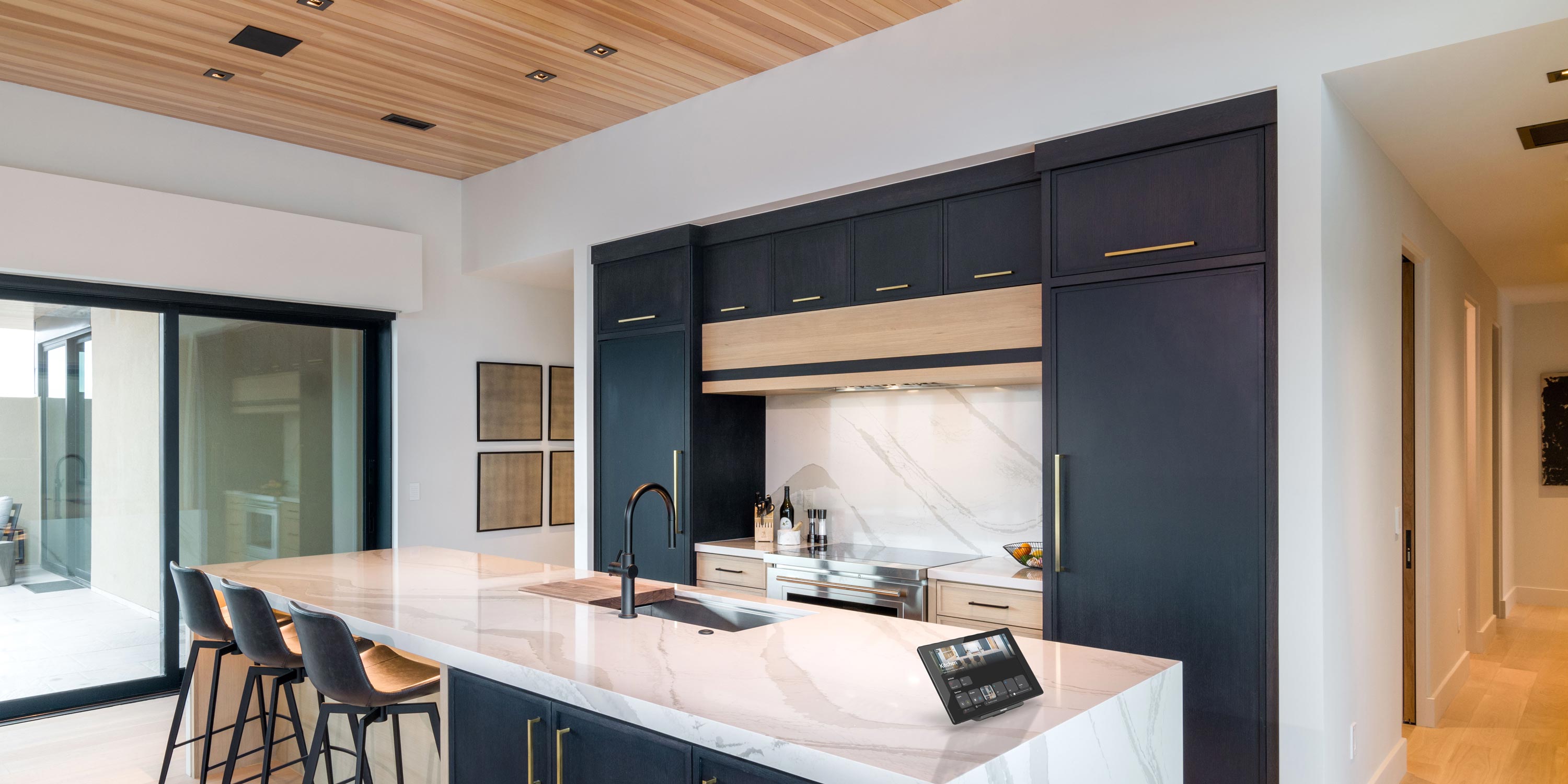 blue cabinets with gold hardware and wooden ceiling with marble countertops crestron touch panel