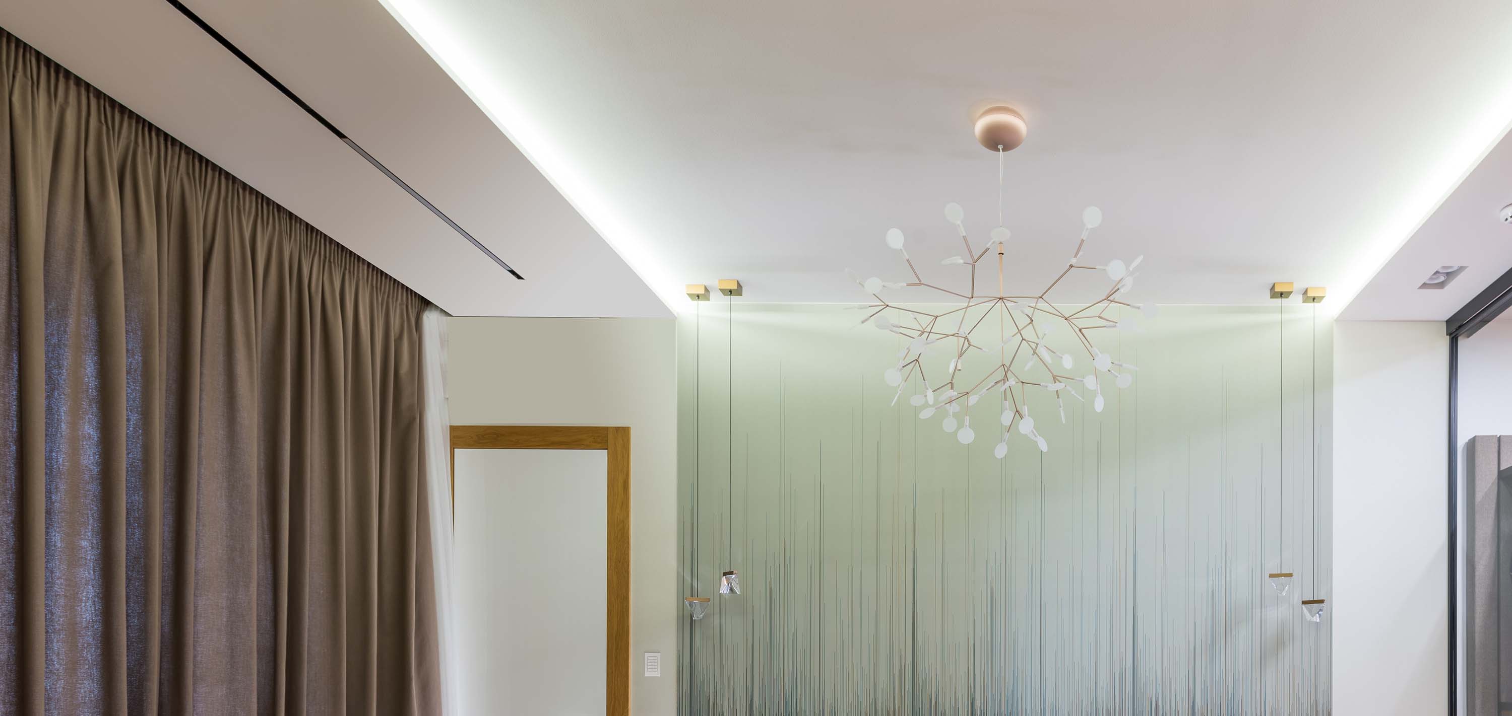 Spacious, contemporary bathroom with linear lighting, a walk-in closet, and a large window overlooking nature.